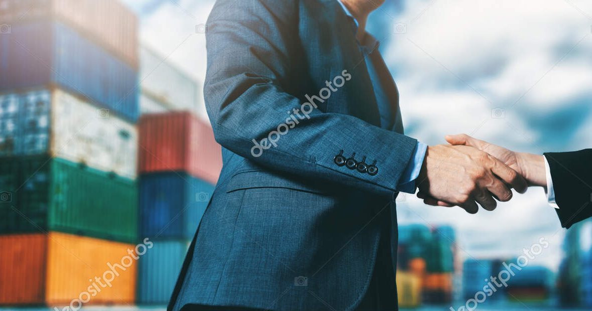 export and import business. businessmen handshake at industrial container terminal. maritime transport and logistics concept